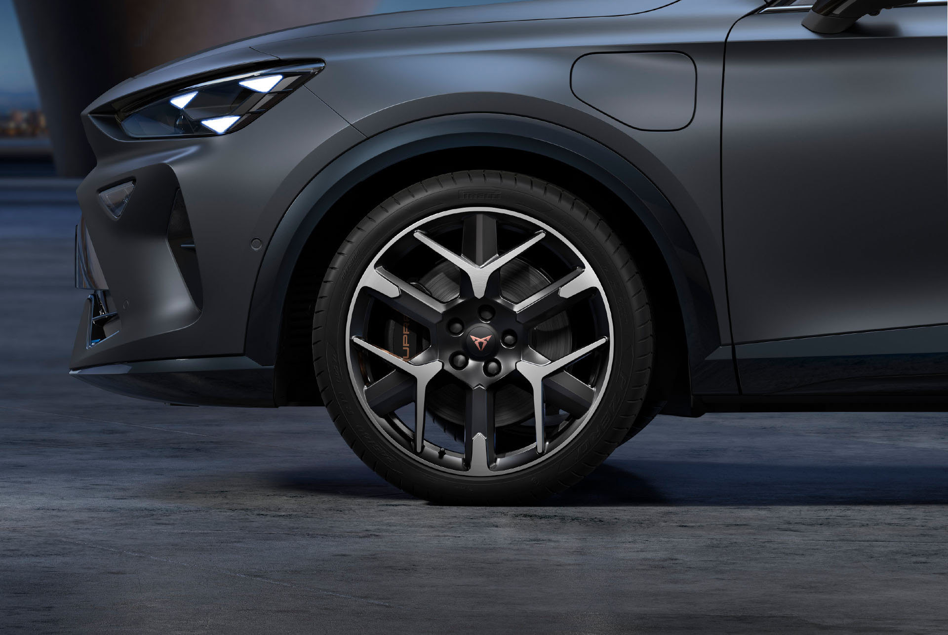 Vue frontale gauche des jantes forgées en argent et en noir, des pneus et des phares signature de CUPRA.
