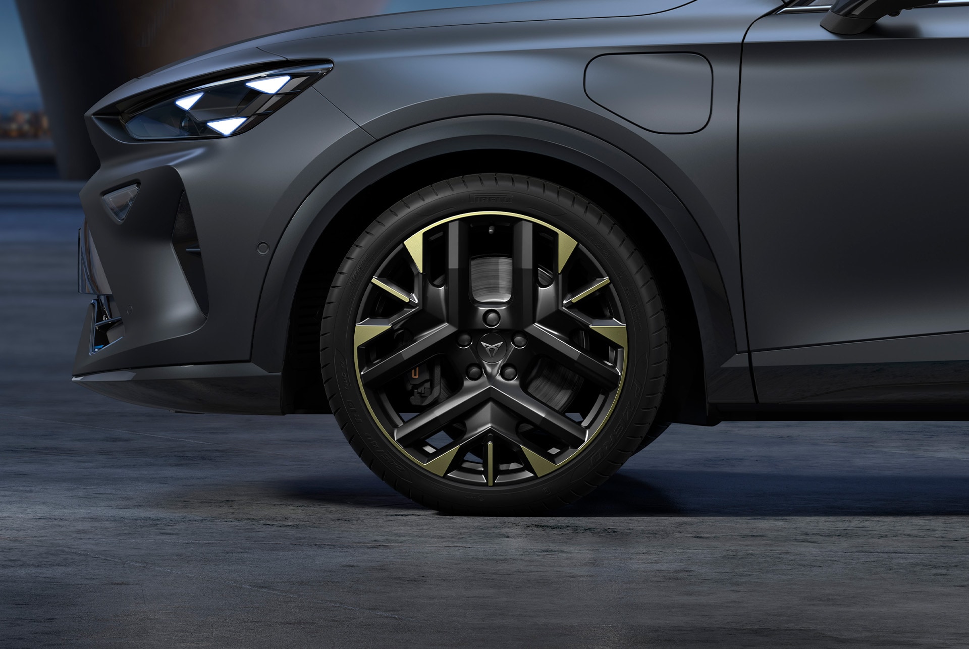 Vue avant latérale de la jante CUPRA côté gauche en Sulfure, avec les pneus et les phares signature, de l’Édition Tribe.