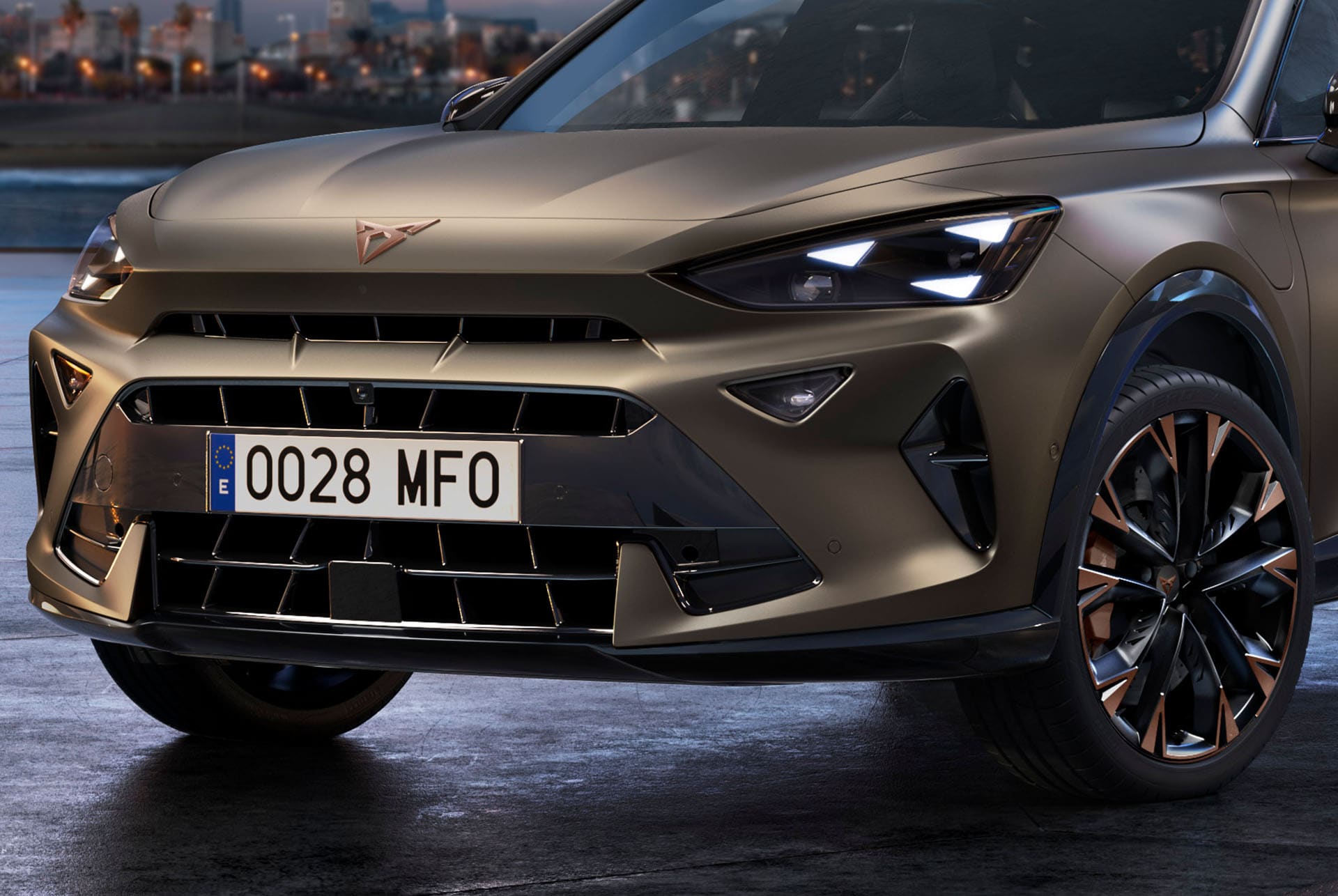 Gros plan sur l’avant du nouveau CUV CUPRA Formentor 2024 en Bronze Century mat, avec des jantes aux accents cuivrés, des feux avant signature triangulaire et le logo CUPRA distinctif.