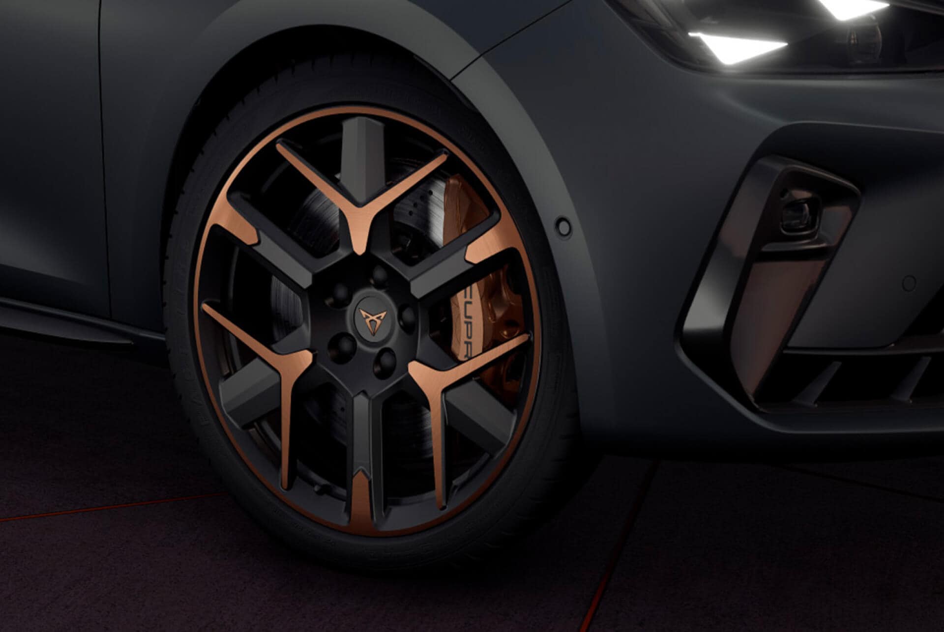 Gros plan des jantes noires aux accents cuivrés et phares à œil triangulaire, de la nouvelle Cupra Leon Sportstourer 2024 en Gris Encelade mat