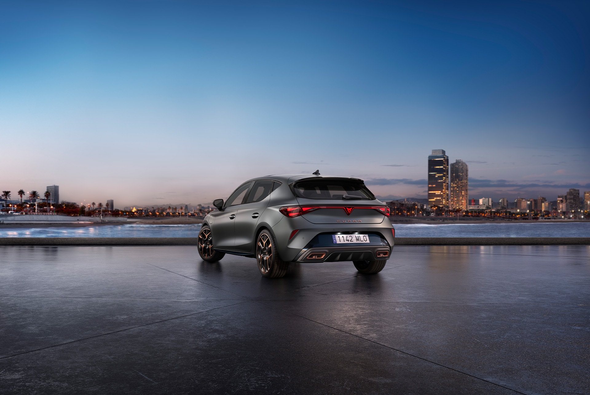 Nouvelle Cupra Leon VZ 2025, ciel bleu, coucher de soleil, éclairage arrière, carrosserie en gris mat.