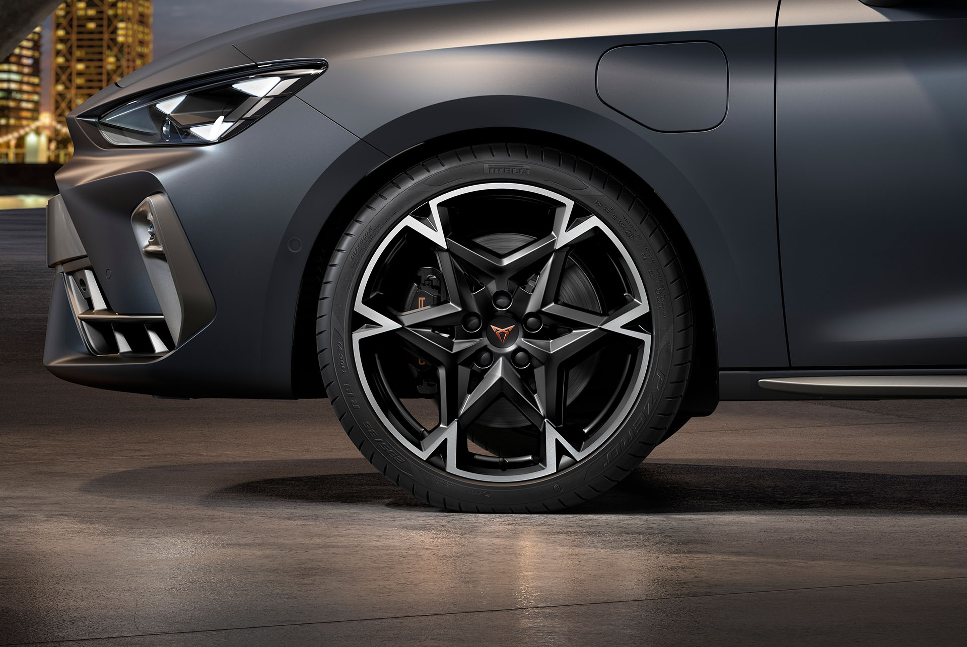 Vue latérale avant gauche des jantes en alliage usinées en Noir et Argent, pneus, phares signature et carrosserie grise de la nouvelle Cupra Leon 2024