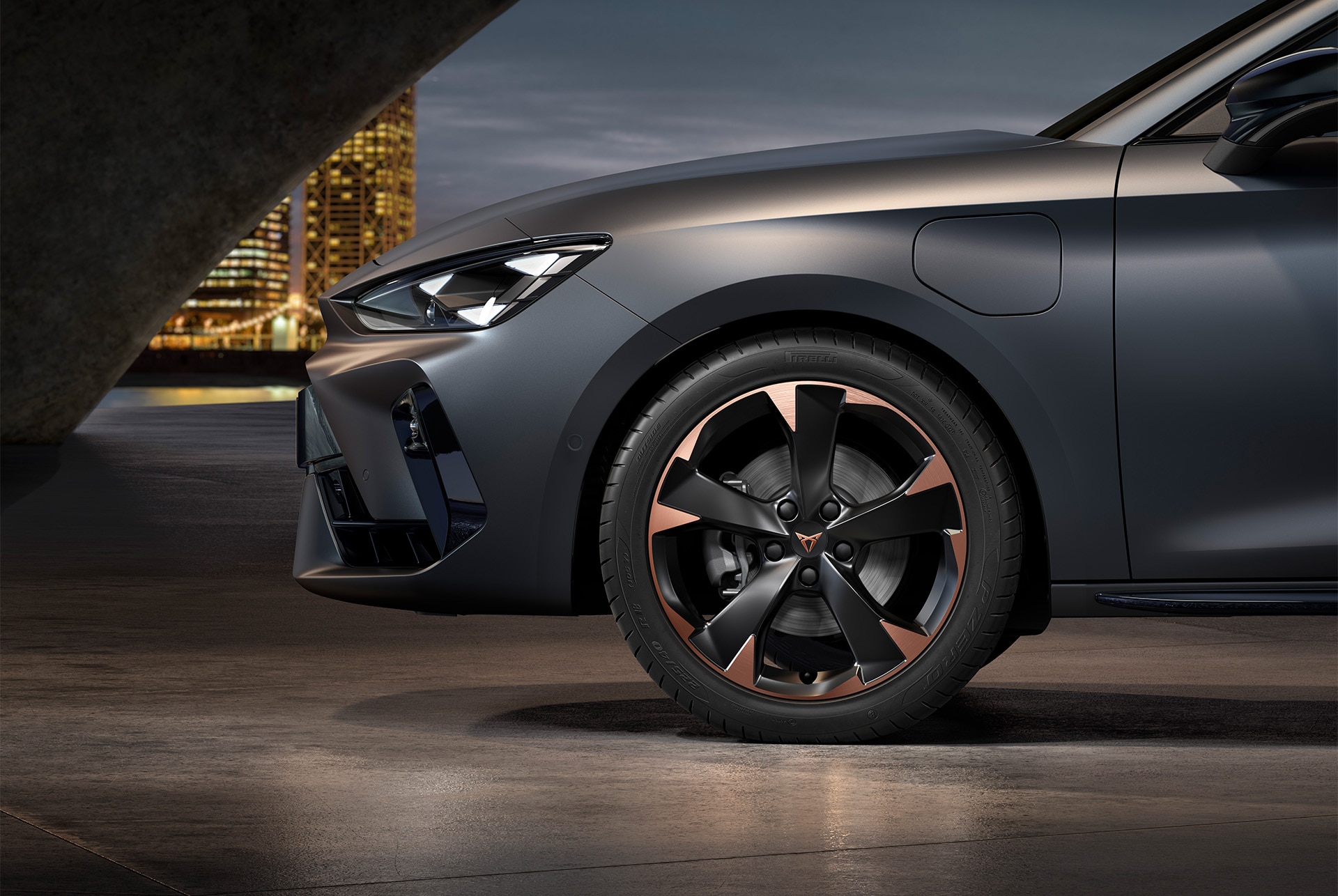 Vue latérale avant gauche des jantes en alliage usinées en Cuivre, pneus, phares signature et carrosserie en gris mat de la nouvelle CUPRA Leon 2025