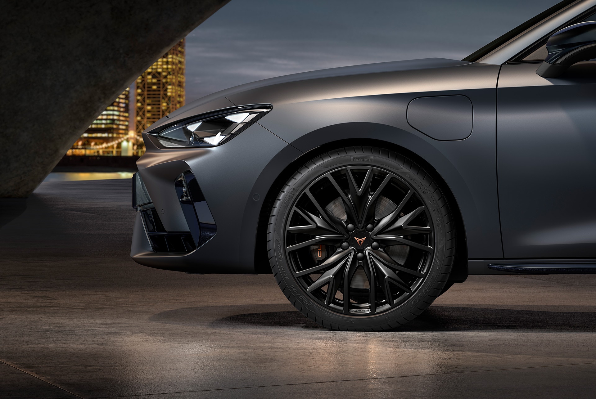 Vue avant latérale de la jante gauche en Noir Sport Mat de la nouvelle CUPRA Leon 2025, avec les pneus, les phares signature et la carrosserie en gris mat.