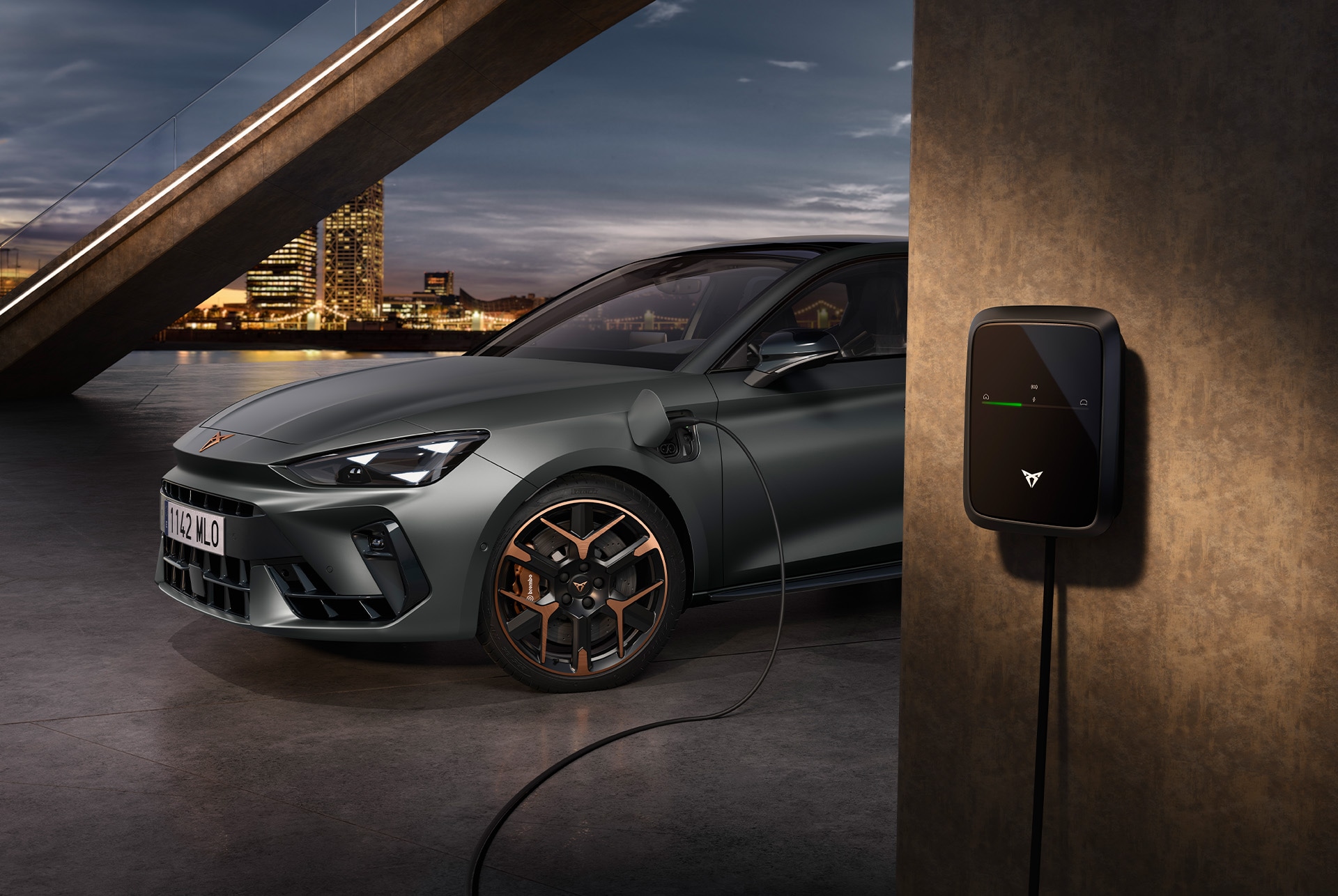 Vue latérale partielle de la CUPRA Leon VZ e-Hybrid branchée dans un environnement urbain.