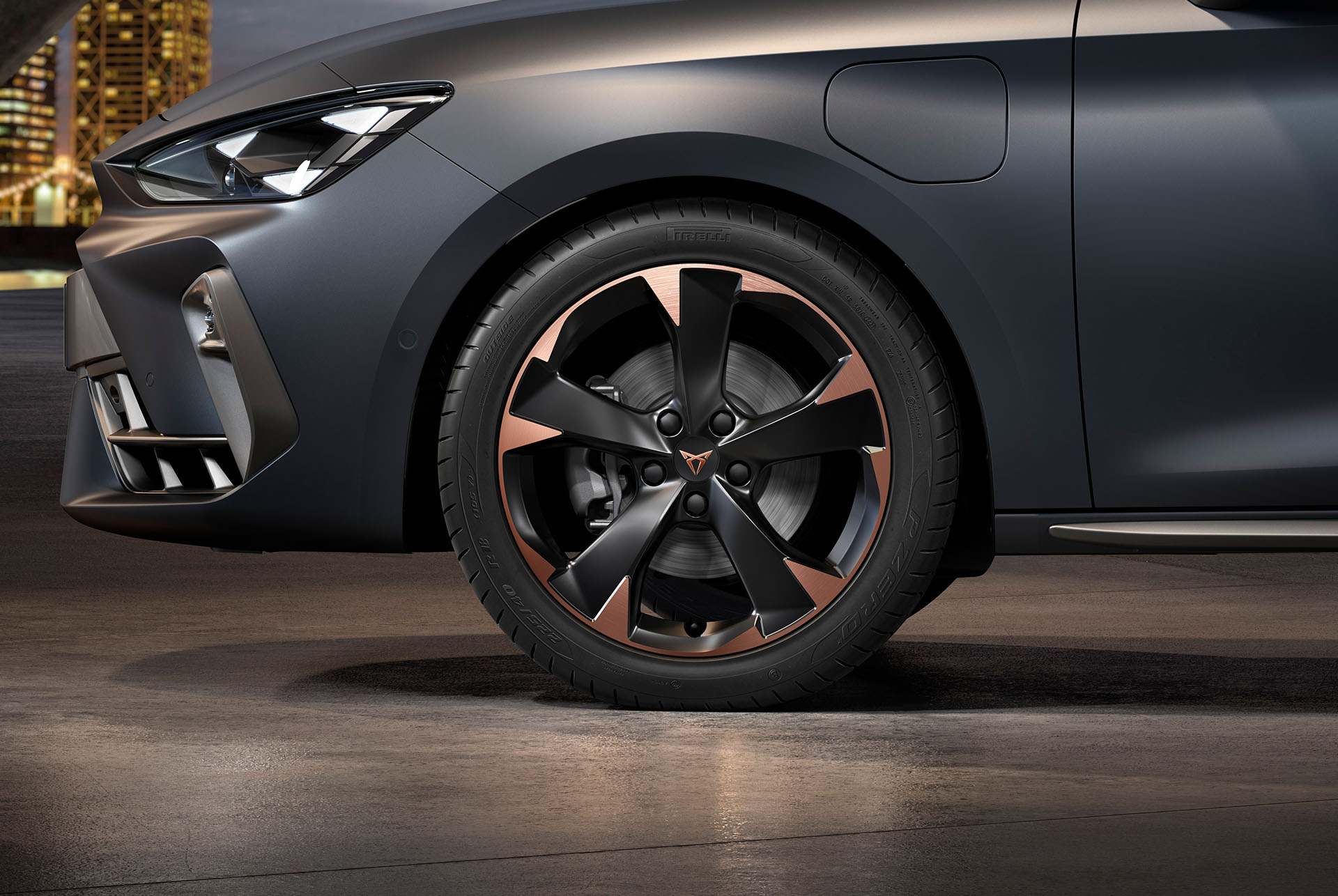 Vue latérale avant gauche des jantes en alliage usinées en Cuivre, pneus, phares signature et carrosserie en gris mat de la nouvelle Cupra Leon Sportstourer 2024