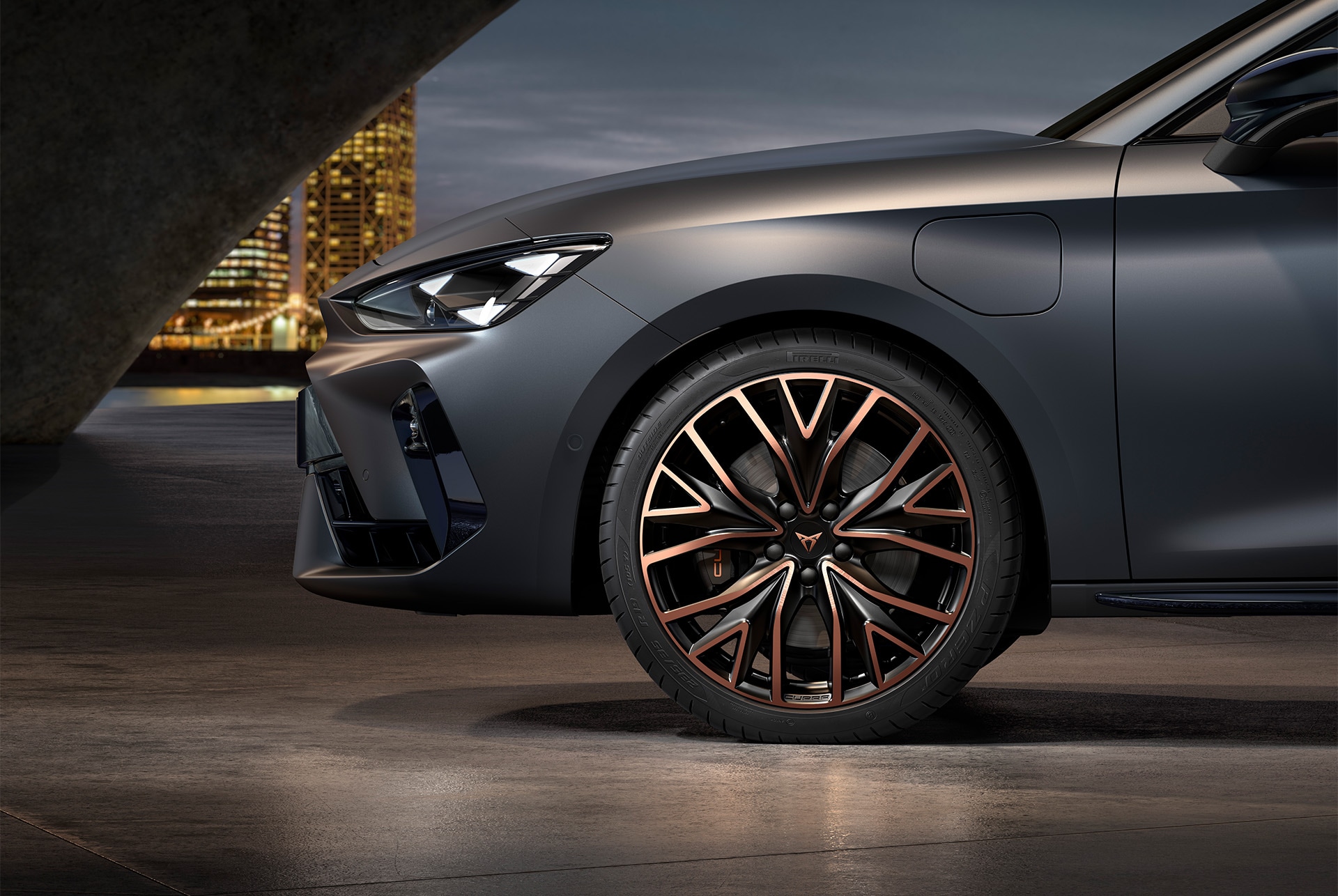 Vue latérale avant gauche des jantes en alliage forgées en Cuivre Mistral et Noir, pneus, phares signature et carrosserie grise de la nouvelle CUPRA Leon 2025