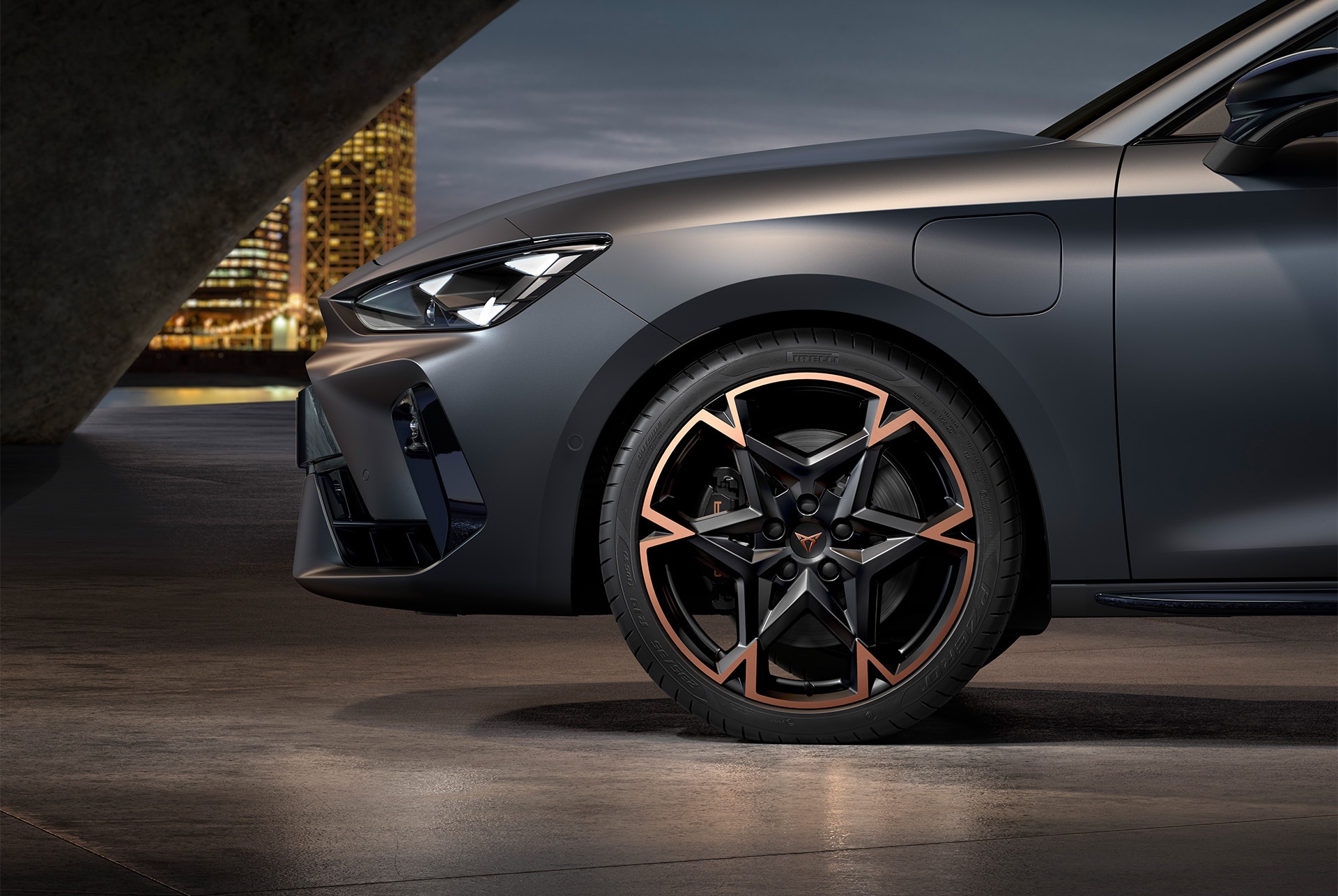 Vue latérale avant gauche des jantes en alliage usinées en Noir et Cuivre, pneus, phares signature et carrosserie en gris mat de la nouvelle CUPRA Leon 2025