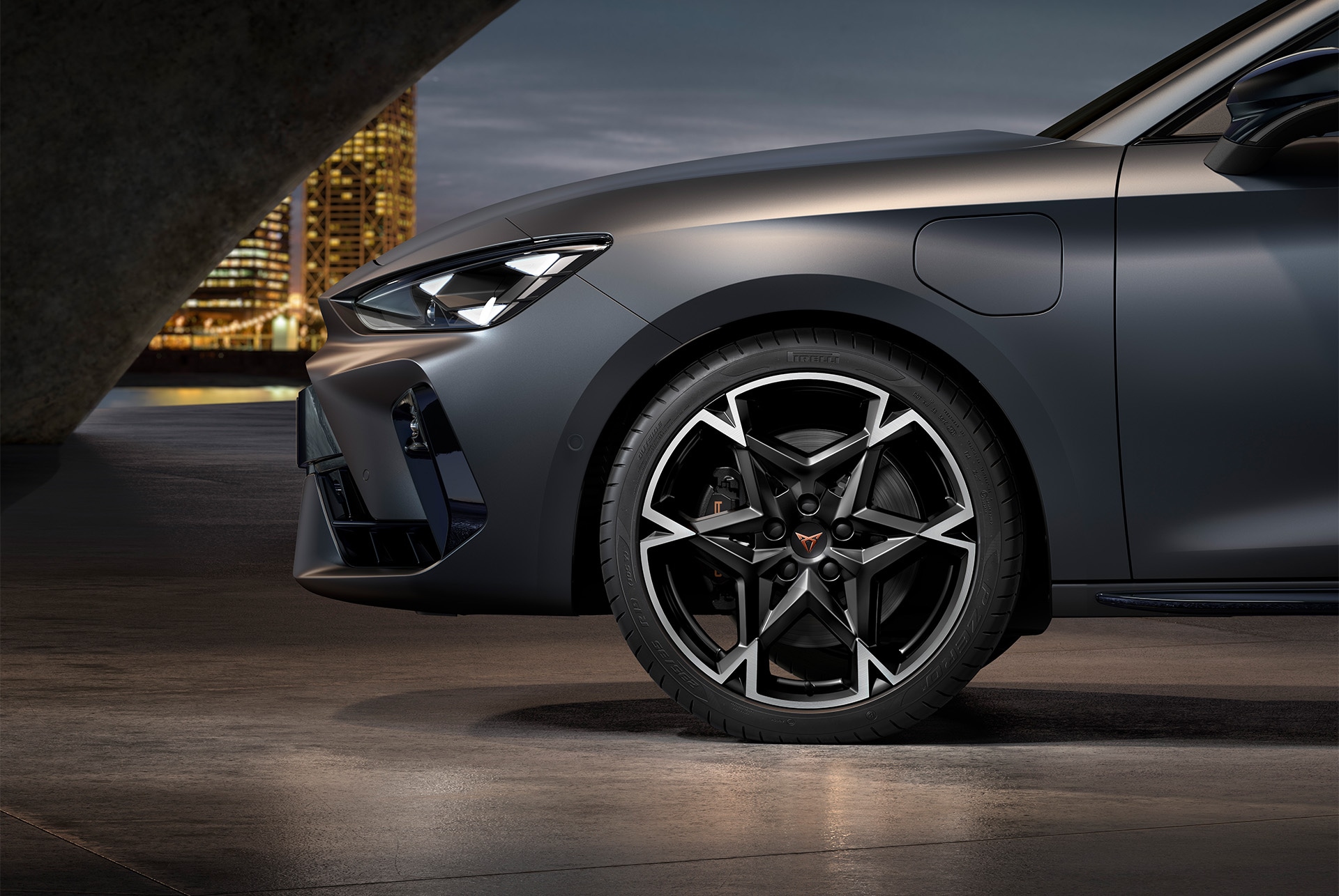 Vue latérale avant gauche des jantes en alliage usinées en Noir et Argent, pneus, phares signature et carrosserie grise de la nouvelle CUPRA Leon 2025