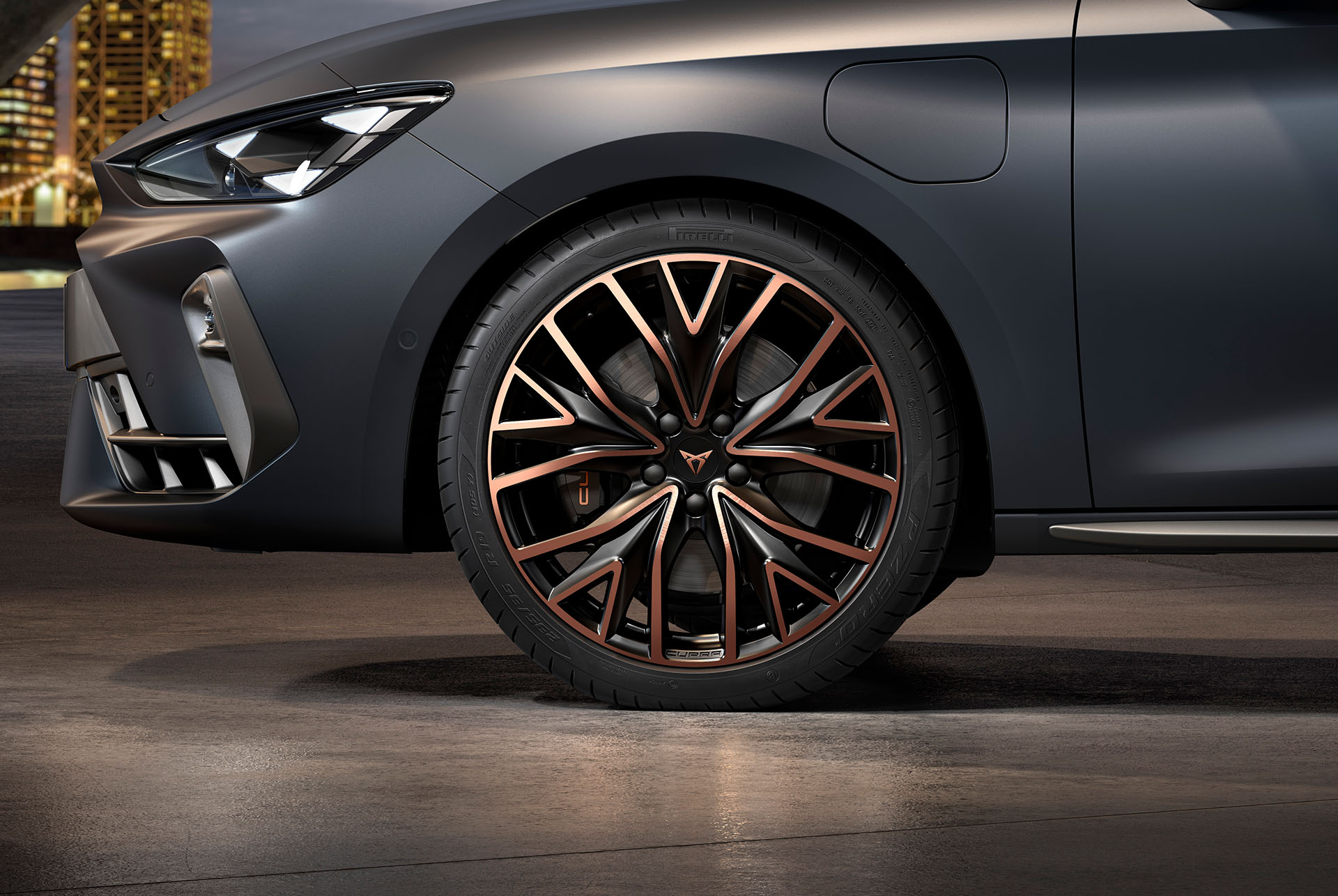 Vue latérale avant gauche des jantes en alliage forgées en Cuivre Mistral et Noir, pneus, phares signature et carrosserie grise de la nouvelle Cupra Leon 2024