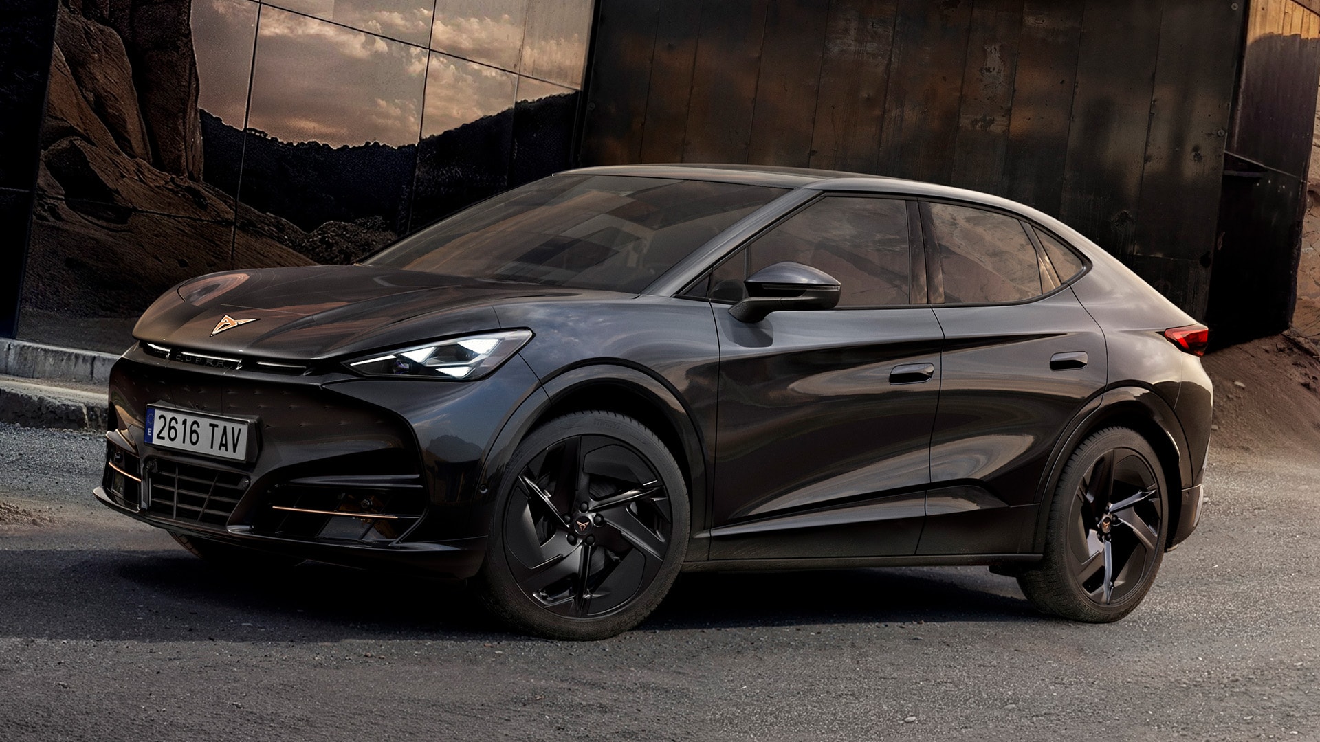 Vue de trois quarts avant du CUPRA Tavascan Black Edition, stationné dans un environnement rocheux et révélant ses éléments de design extérieur comme les jantes en alliage 21 pouces Katla noires.