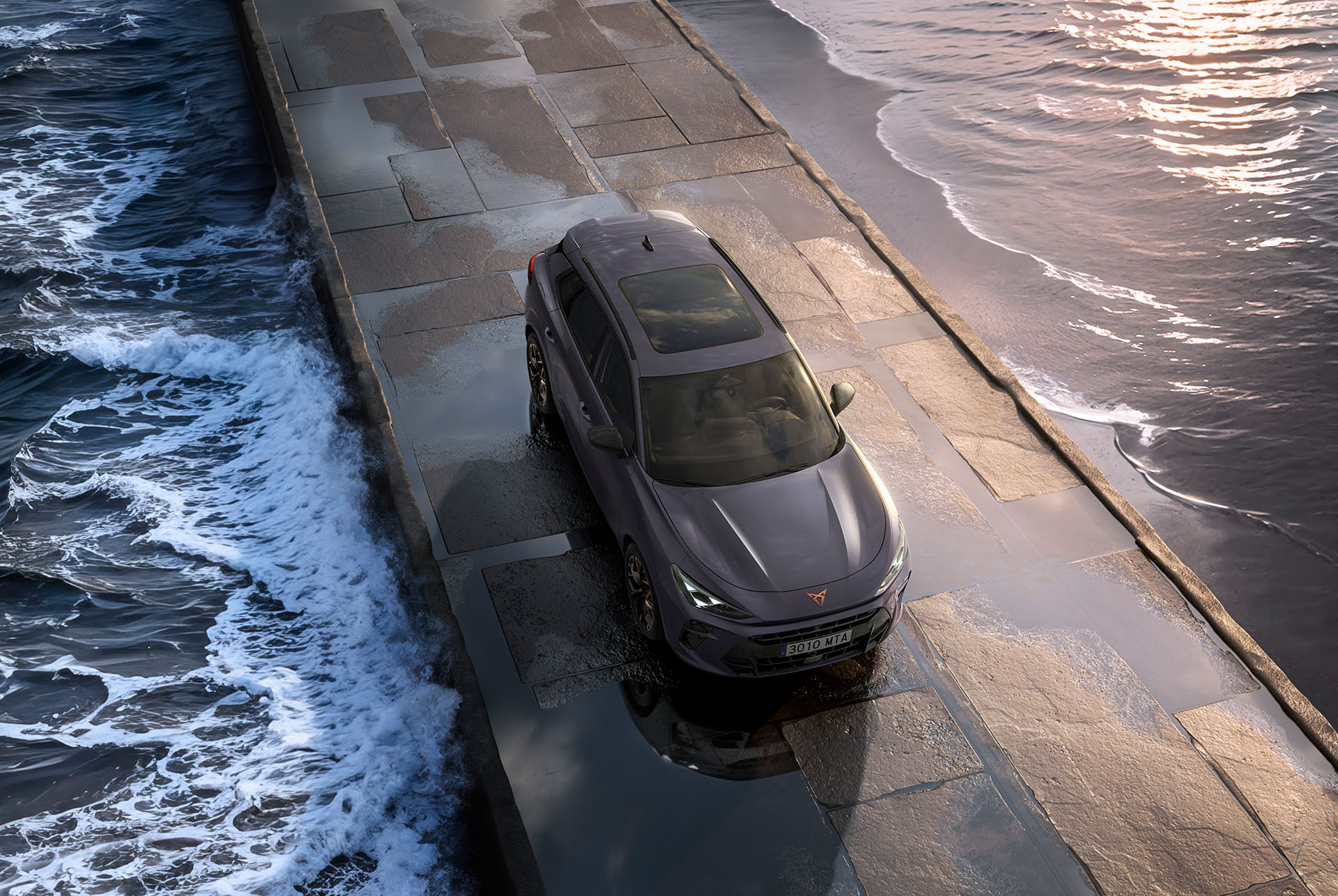 nouveau modèle suv hybride CUPRA Terramar 2025 doté d’un toit ouvrant panoramique, d’un design épuré et de jantes en alliage modernes sur une chaussée mouillée en bord de mer, vue du dessus.