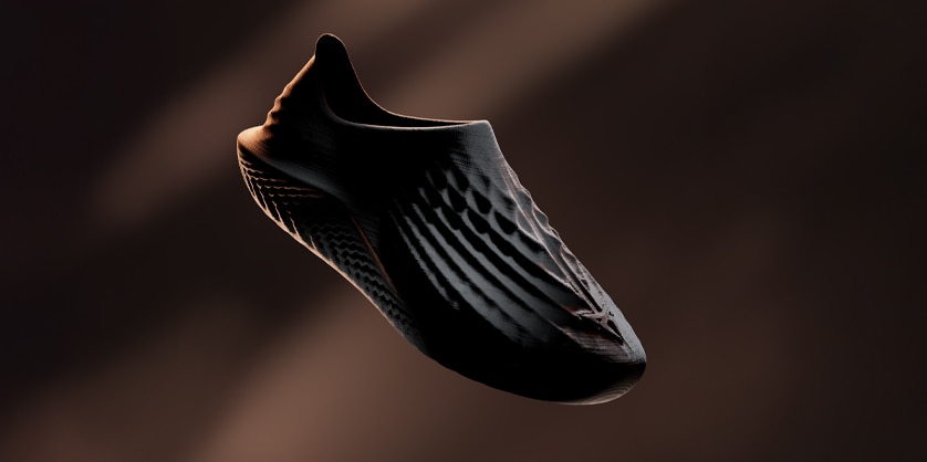 Une chaussure foncée et texturée avec un motif côtelé présentée sur un fond sombre.