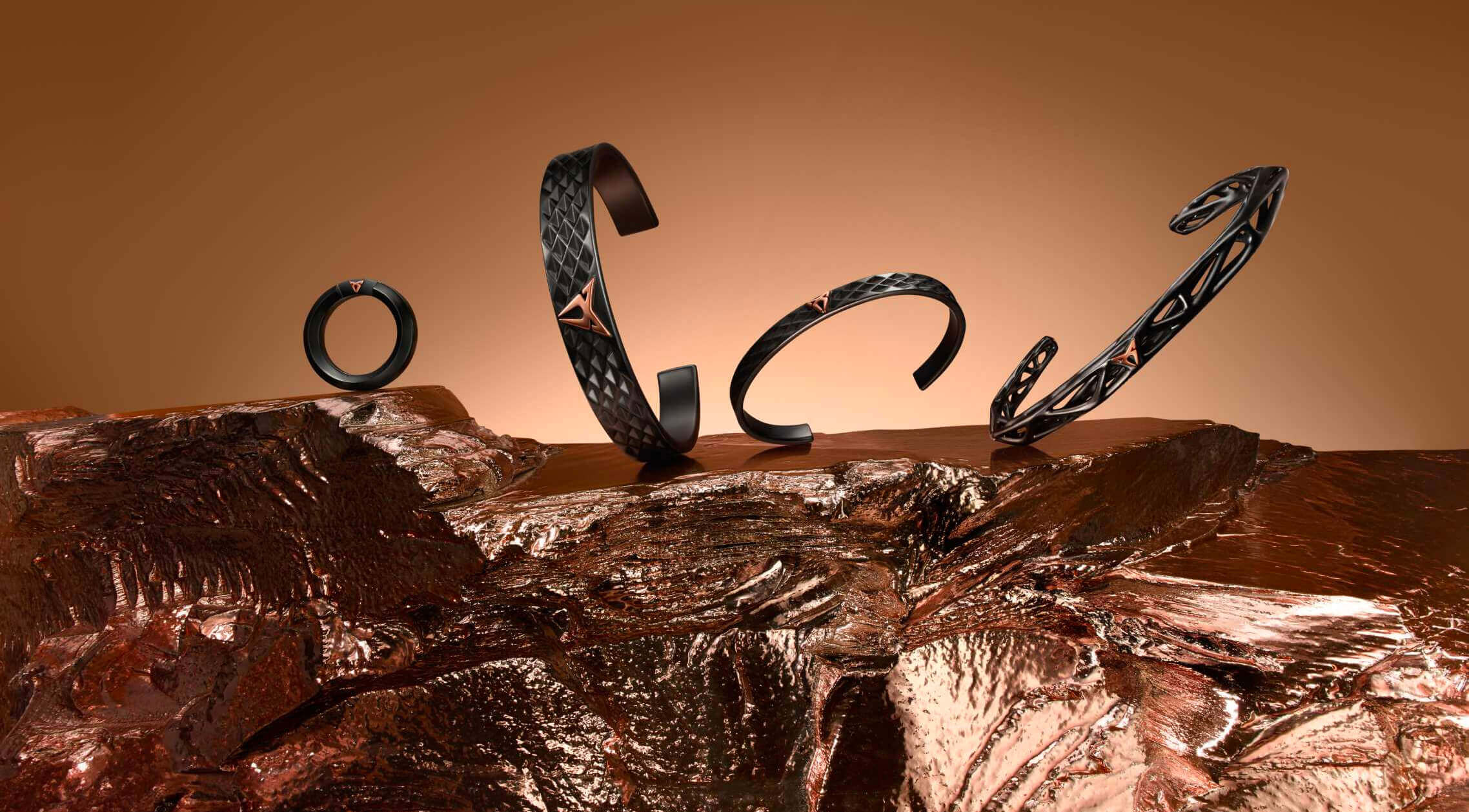 Quatre bracelets noirs texturés avec des finitions métalliques triangulaires, disposés sur du métal fondu ou de la roche. Quatre bracelets noirs texturés avec des finitions métalliques triangulaires, disposés sur du métal fondu ou de la roche.