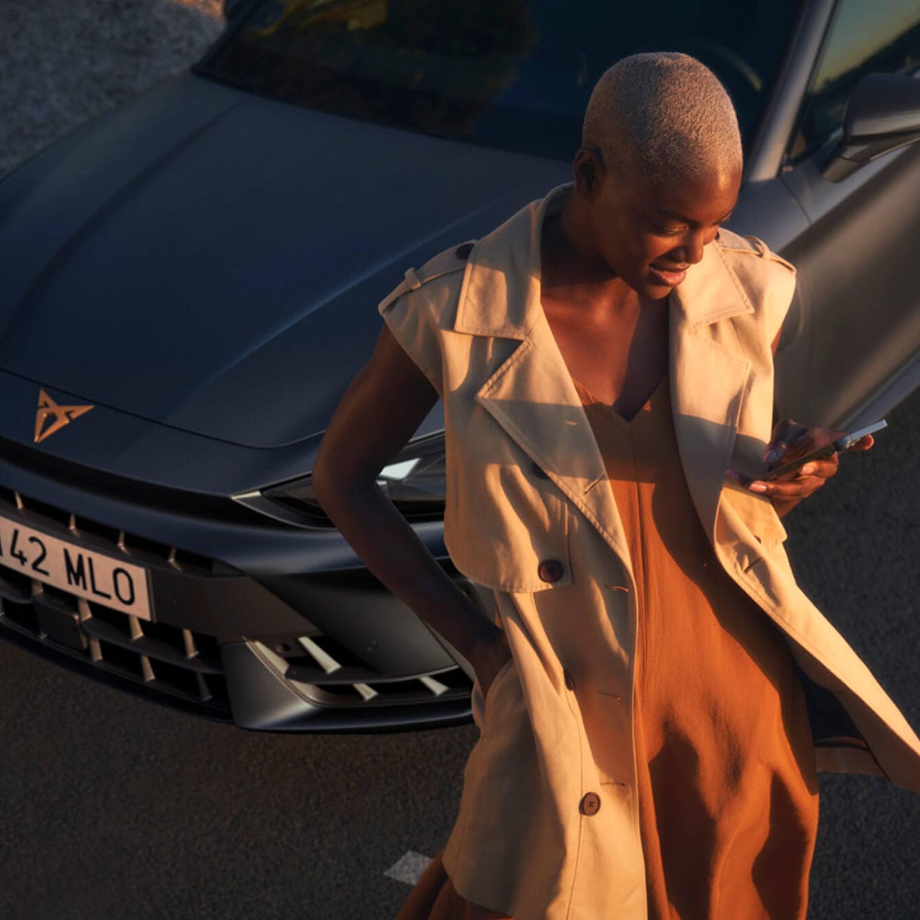 Un professionnel utilisant l’application My CUPRA à côté d’une voiture hybride rechargeable CUPRA, idéale pour les entreprises de location de voitures et les gestionnaires de flotte.