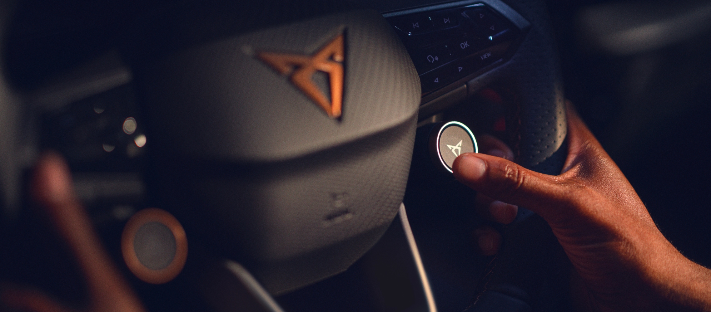 Cupra born, volant avec boutons satellites et logo cupra aux accents cuivrés, gros plan à l’intérieur d’une voiture de société.