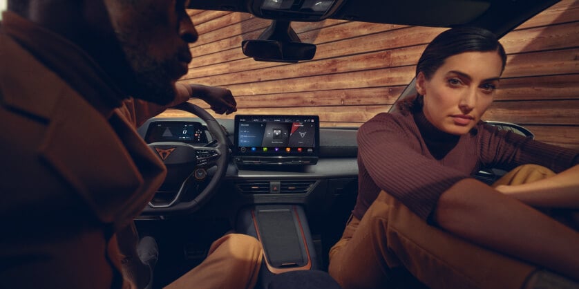 Habitacle de la voiture d’entreprise CUPRA Born, écran d’infodivertissement et modèle sur le siège avant.