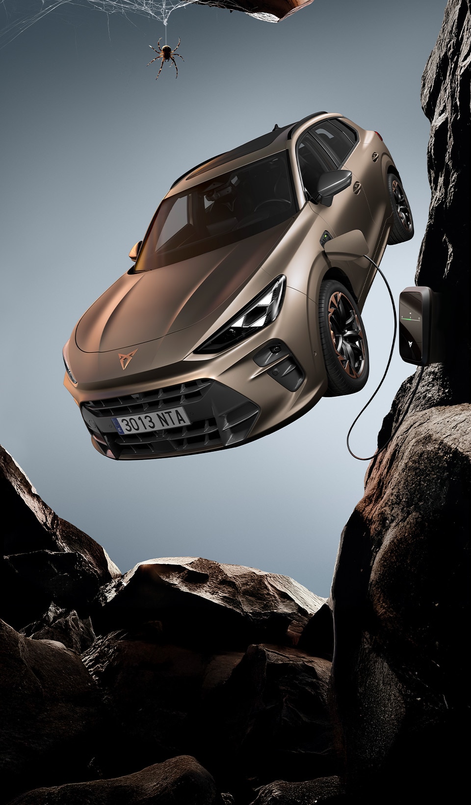 A CUPRA Leon hatchback seen from an elevated angle with its headlights on, next to a person covered in dark, flowing fabric that drapes onto the ground.