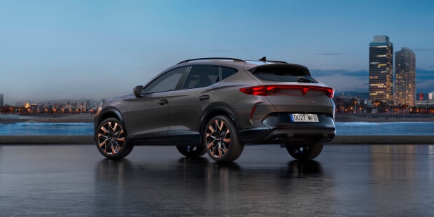 cupra tavascan plugged in to wall charger in dark garage setting